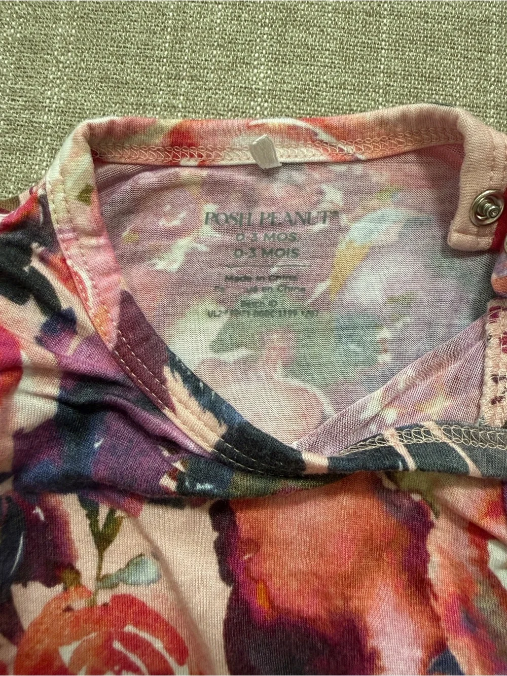Posh Peanut twirl bodysuit features a Dusk Rose floral print 0-3M